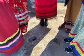 Feet of five people wearing indigenous clothing