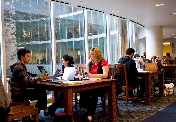 Students sitting together at a table in Millar Library all with laptops open.