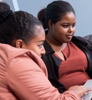 a coach and a student looking together at a laptop