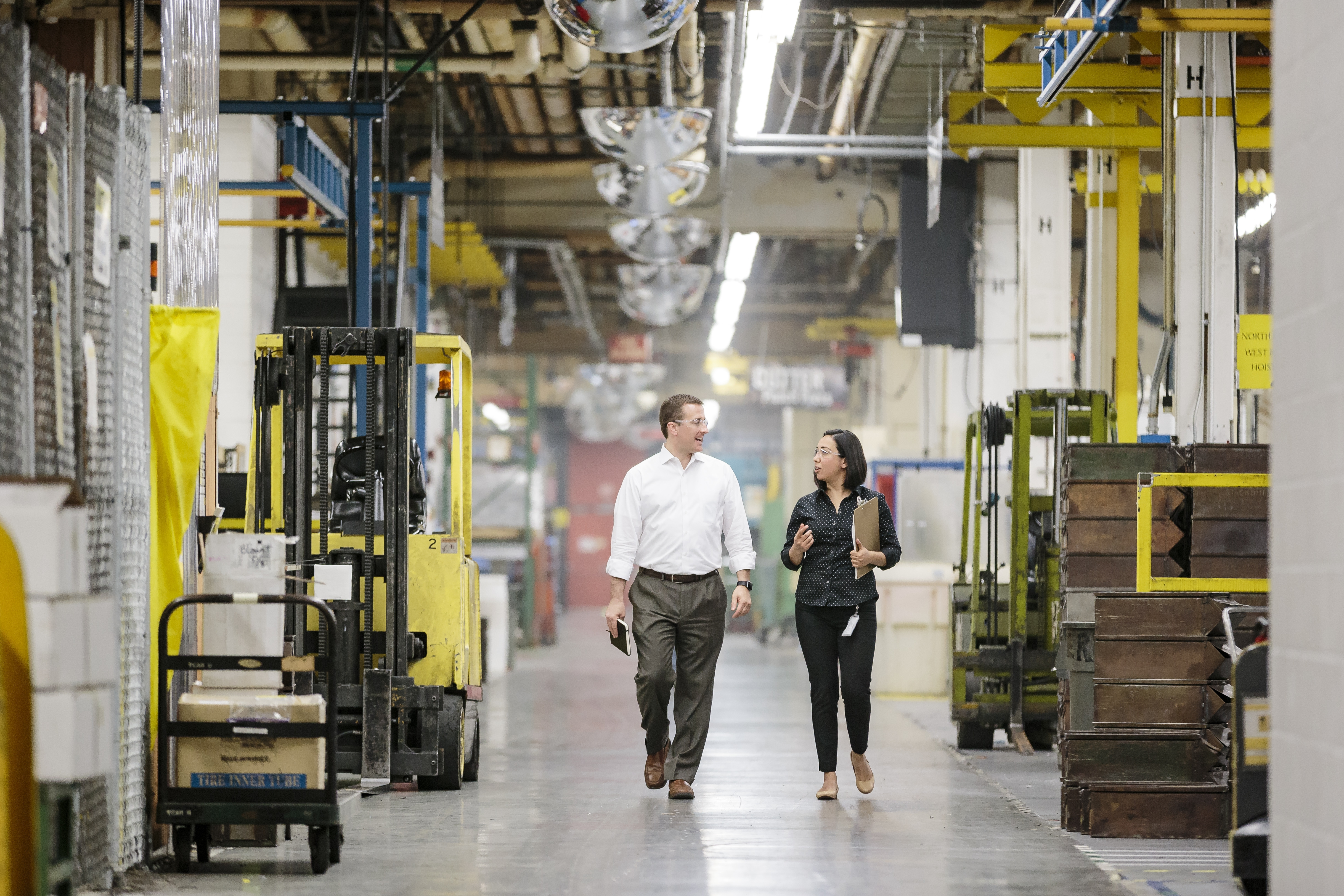 two individuals walking through a warehouse together